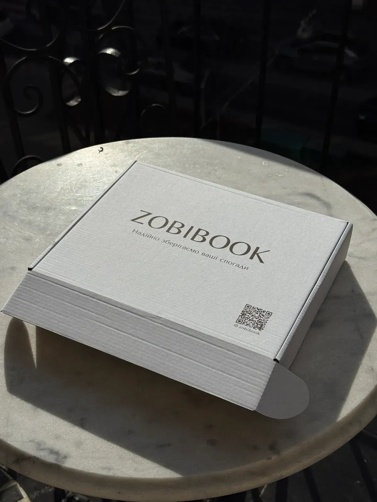 Белая коробка Zobibook с надписью «Надёжно сохраняем ваши воспоминания»