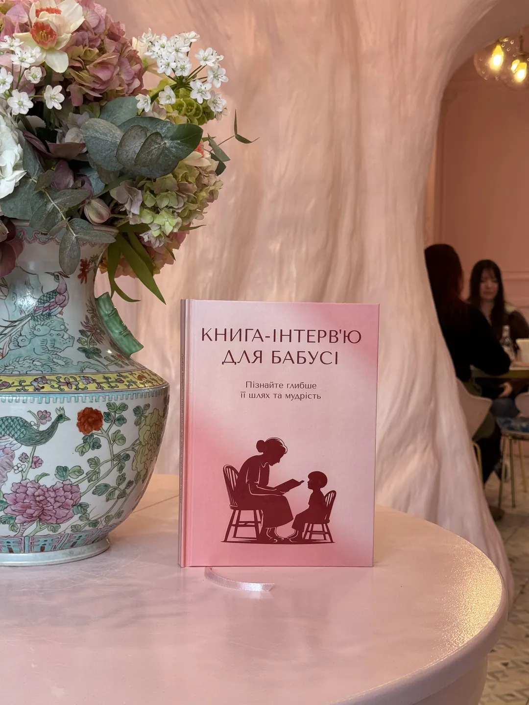 Книга-интервью для бабушки рядом с вазой с цветами